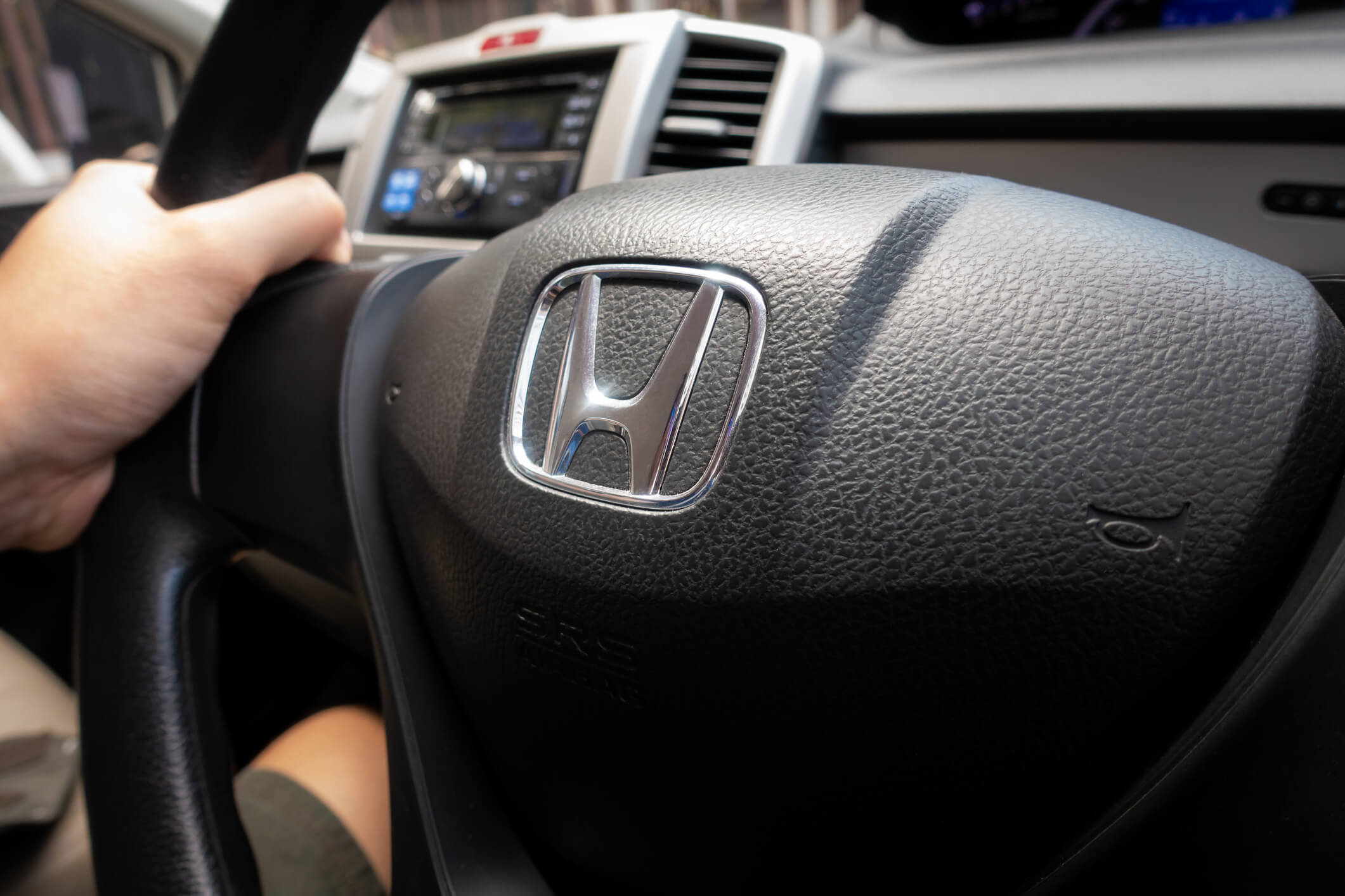 Man inside a Honda Accord, holding the steering wheel.